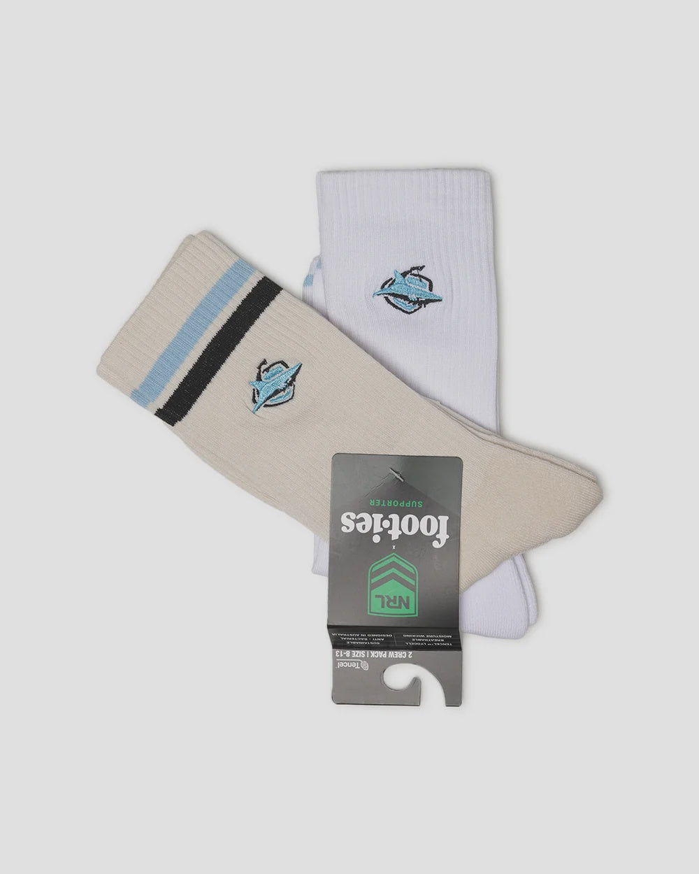 A pair of Footies NFL crew socks, one cream and one white, both featuring a Carolina Panthers logo on the upper calf and a striped cuff. The cream sock has light blue and black stripes, while the white sock has a single light blue stripe.