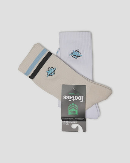 A pair of Footies NFL crew socks, one cream and one white, both featuring a Carolina Panthers logo on the upper calf and a striped cuff. The cream sock has light blue and black stripes, while the white sock has a single light blue stripe.