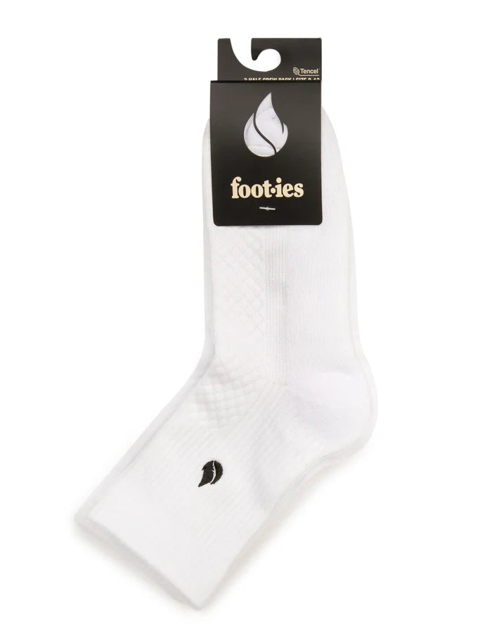 White foot-ies Blaze half crew socks folded with black branded retail packaging and a visible black flame logo.