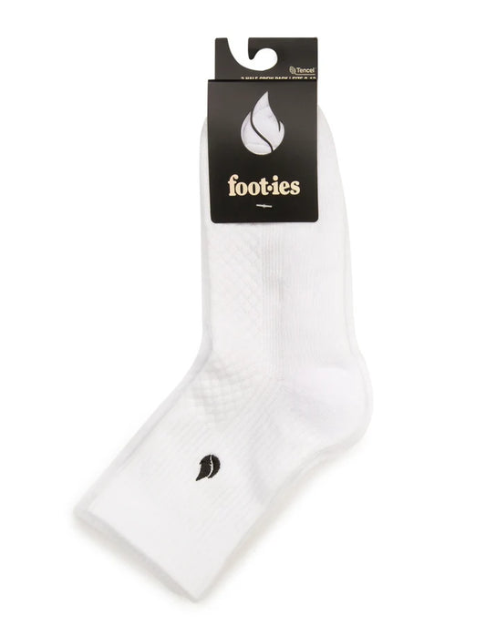 White foot-ies Blaze half crew socks folded with black branded retail packaging and a visible black flame logo.