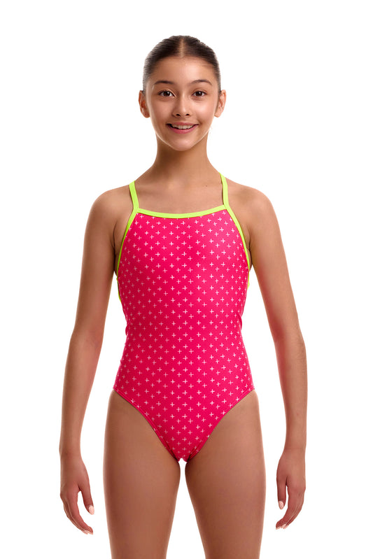 Front view of a young girl wearing the Funkita Strapped In one-piece swimsuit in bright pink with a subtle white plus/cross pattern and lime green shoulder straps.