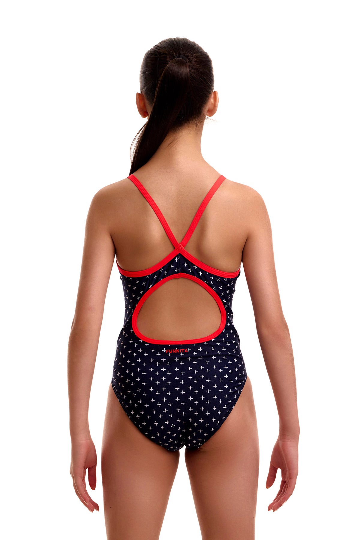 Back-side view of young swimmer modeling Funkita Girls Very Cross one-piece swimsuit with red double-bind straps.