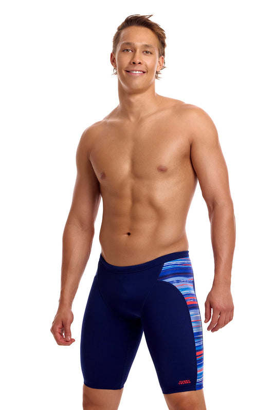 A male athlete standing against a white background modeling the Funky Trunks "Lost Lines" Men's Swim Jammers, featuring a dark navy body with a colorful, multi-striped accent panel along the side.