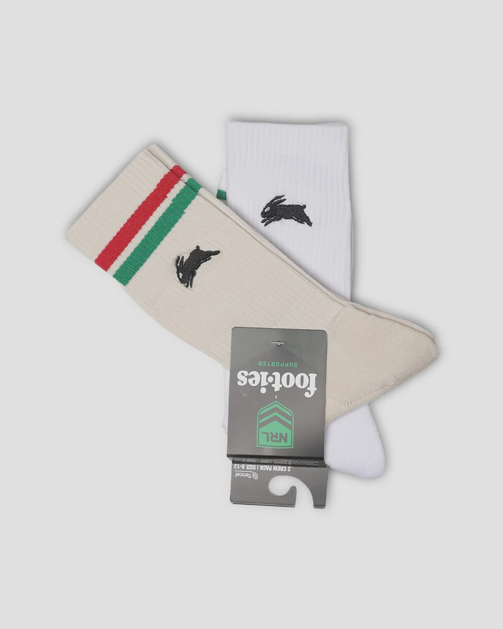 A pair of ankle socks with a black rabbit logo, featuring one cream sock with green and red stripes and one white sock, both with a grey 'footies NRL' hangtag.