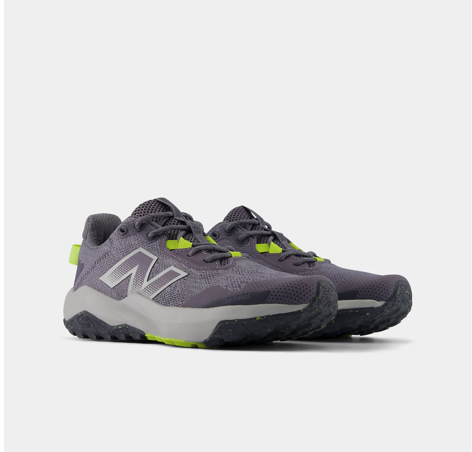 Pair of grey and black New Balance Big Kids Nitrel Lace trail running shoes with bright yellow accents on the lace loops and outsole, shown at a three-quarter angle against a light grey background.