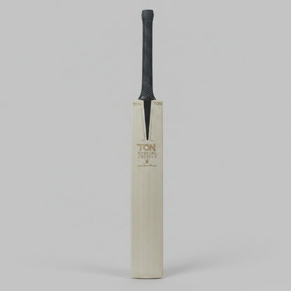 A single cricket bat standing upright against a dark gray background. The bat has a light natural wood blade with gold-toned 'TON' branding and a dark gray textured grip.