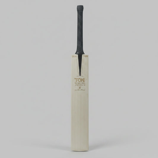 A single cricket bat standing upright against a dark gray background. The bat has a light natural wood blade with gold-toned 'TON' branding and a dark gray textured grip.