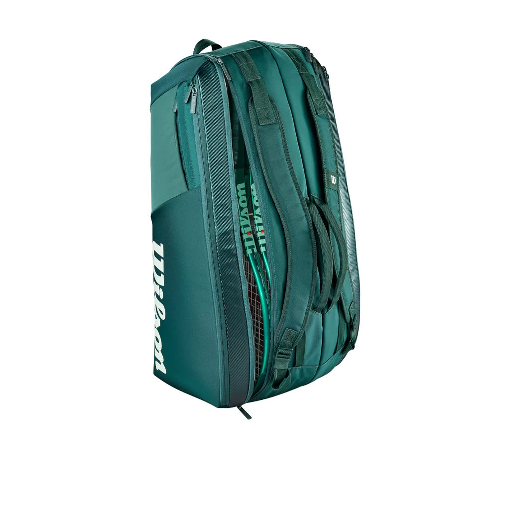 Green Wilson Blade V10 racket bag standing upright with rackets visible in an open compartment.