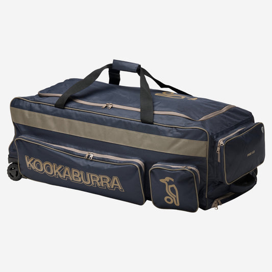 Kookaburra Pro 1.0 Wheelie Cricket Bag Navy/Taupe - Angled view showing external pockets, heavy duty wheels, and reinforced pull handle