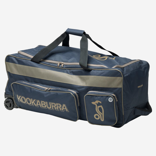 Kookaburra Pro 3.0 Cricket Wheelie Bag Navy/Taupe - Angled view showing external pockets including cooler-lined side pocket, heavy duty wheels, and reinforced pull handle