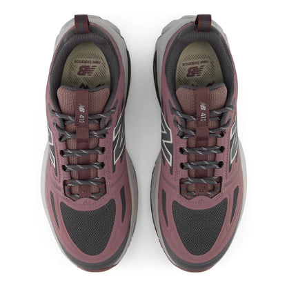 Top view of a pair of New Balance Women's 410v9 trail running shoes in Fast Track/Pebble placed side-by-side, showcasing dark grey mesh toe boxes, dusty rose-pink synthetic overlays, dark grey patterned laces, and grey Fresh Foam midsoles against a white background.