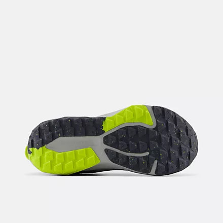 Bottom view of the dark grey AT Tread rubber outsole on the New Balance Big Kids Nitrel Lace trail running shoe, featuring bright yellow traction lugs against a light grey background.