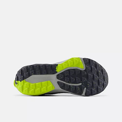 Bottom view of the dark grey AT Tread rubber outsole on the New Balance Big Kids Nitrel Lace trail running shoe, featuring bright yellow traction lugs against a light grey background.