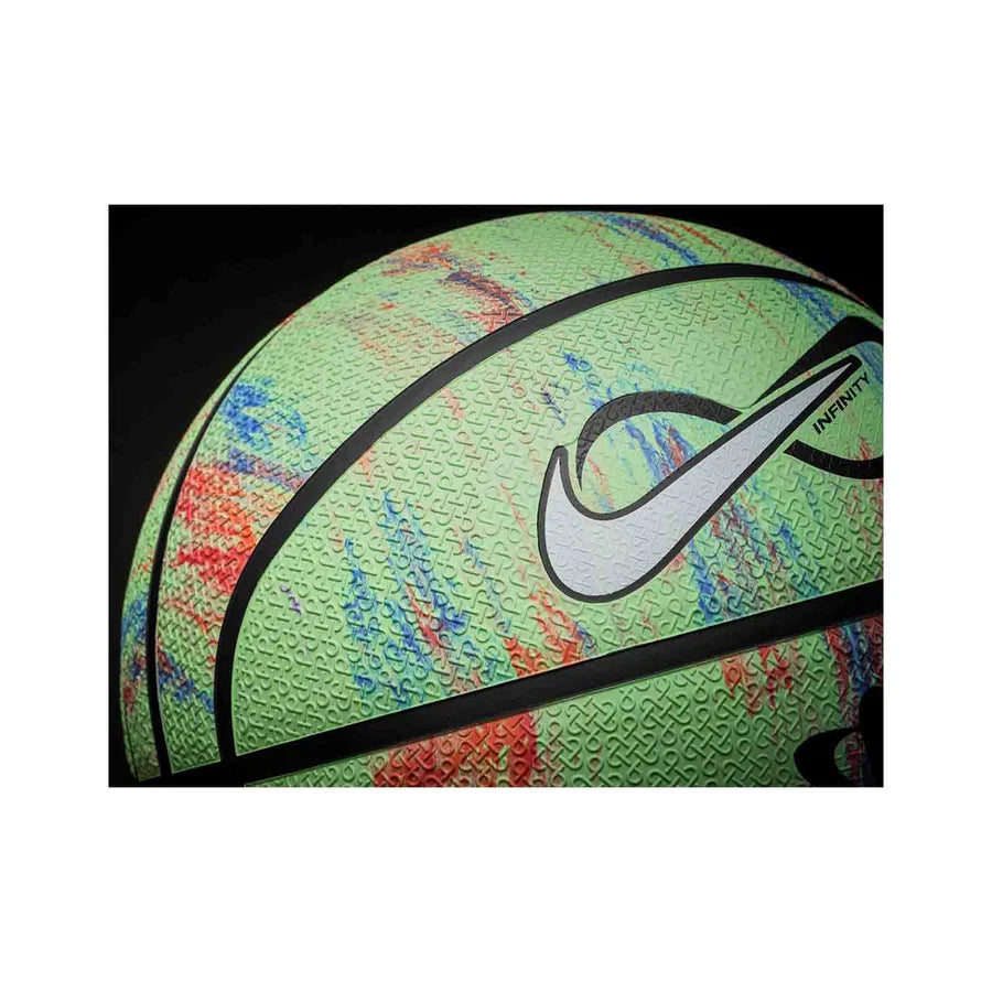 A close-up of a Nike basketball featuring a textured light green surface with multicolor red, blue, and orange speckles, a white Nike swoosh, and black lines, set against a black background.
